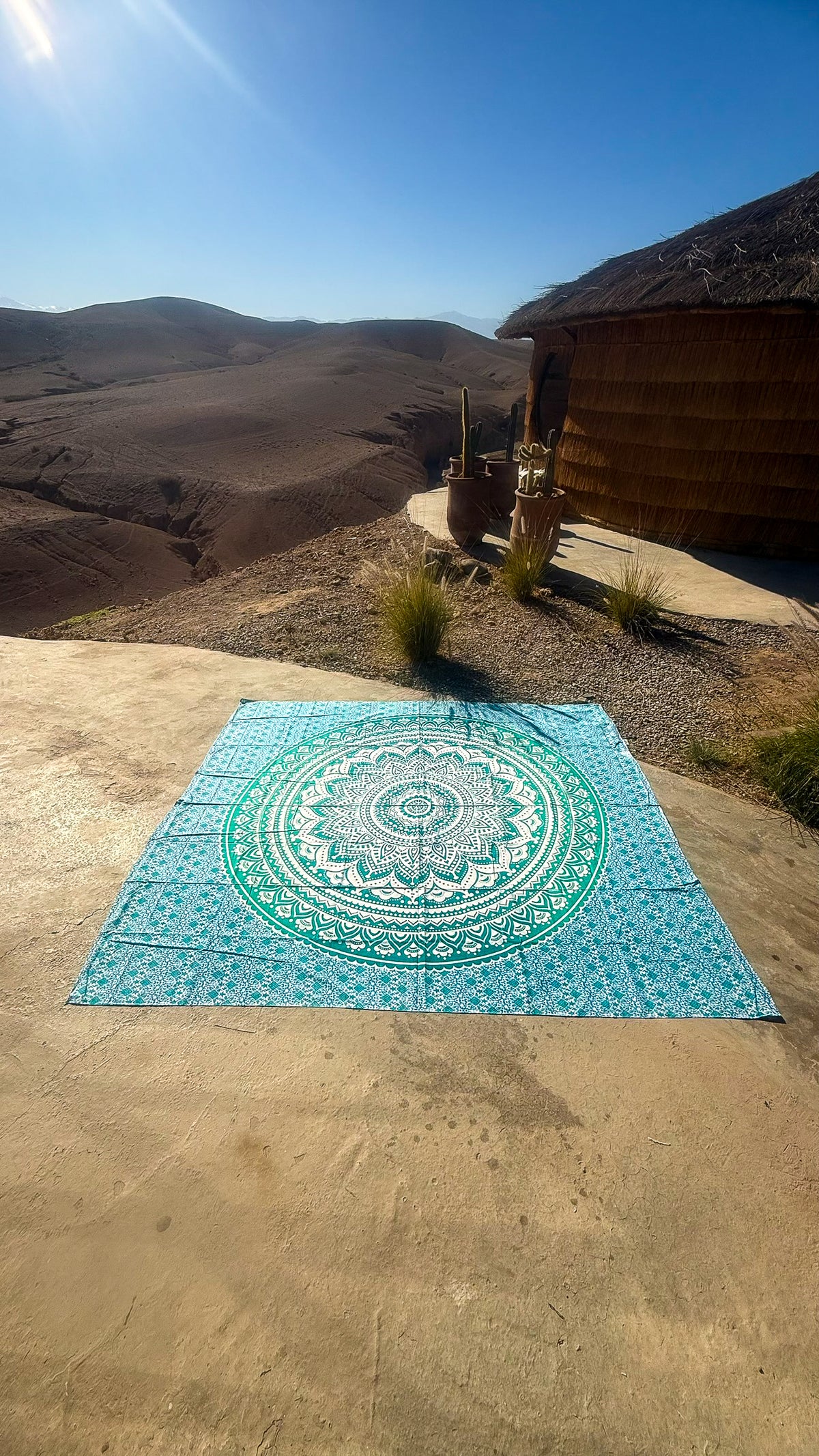 XXL strandlaken Green Ombre 235x220 cm, uitgespreid op zandsteen onder een blauwe lucht
