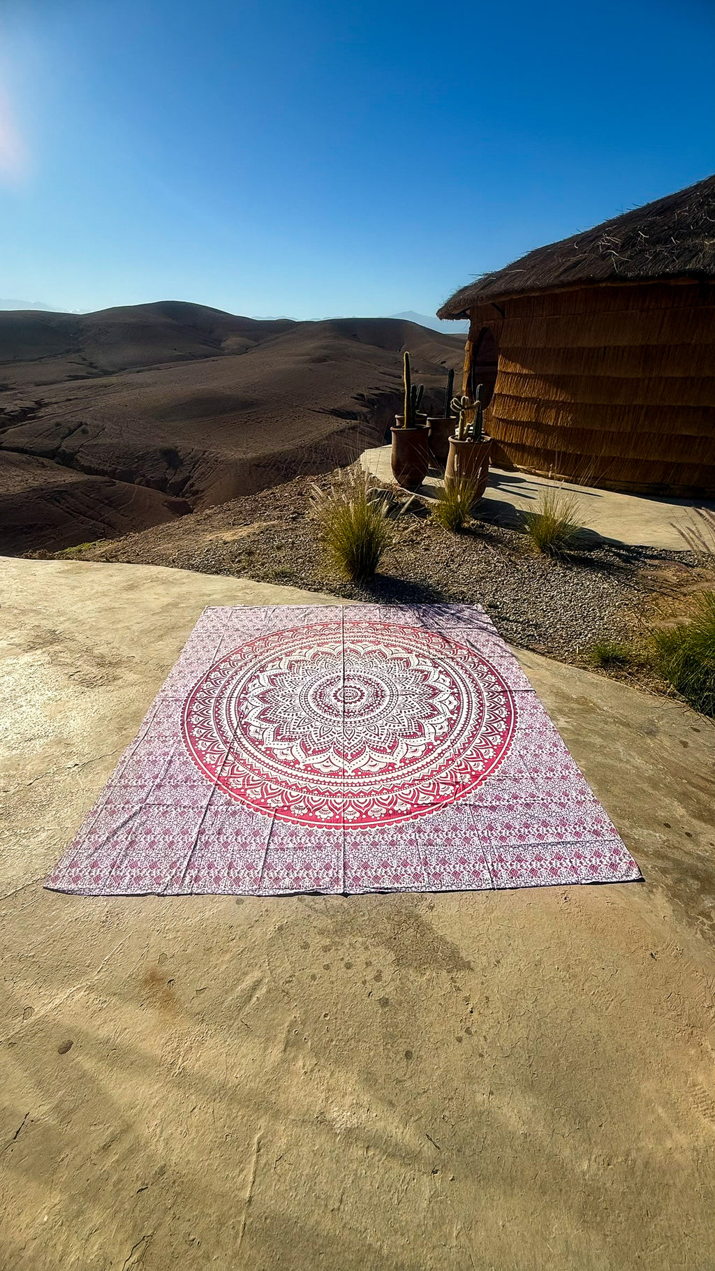 XXL strandlaken Pink Ombre 235x220 cm, uitgespreid op een zonnige rots met uitzicht op de bergen