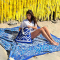 XXL beach towel Star Blue 235x220 cm, with a woman sitting on the beach