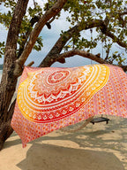 XXL beach towel Yellow Orange Ombre 235x220 cm, hanging from a tree by the sea