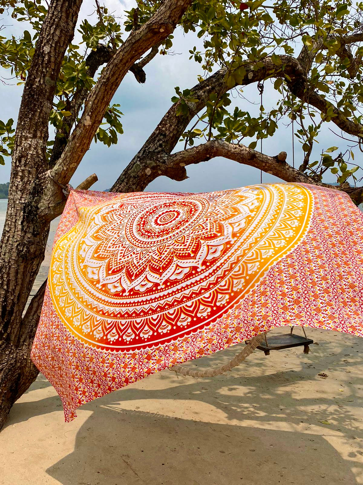 XXL strandlaken Geel Oranje Ombre 235x220 cm, hangend aan een boom aan zee
