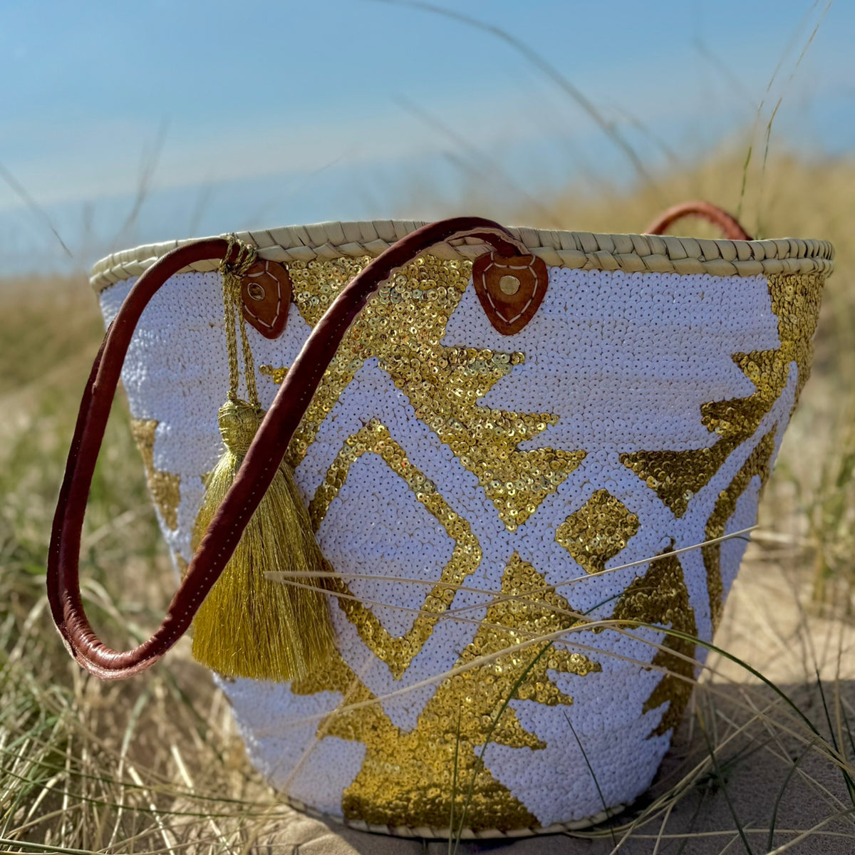 Boho rattan beach bag Aztec white and gold, side view in the dunes