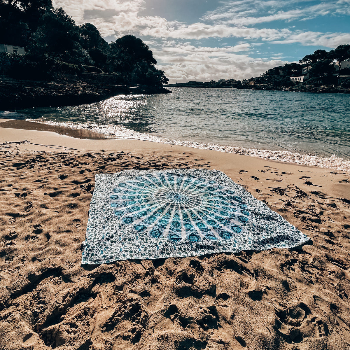 XXL strandlaken Ocean 235x220 cm, uitgespreid op het strand bij de baai