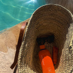Rattan shoulder bag with leather handles and envelope pocket, inside of the bag by the pool